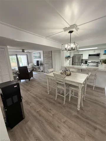 Dining room with dark wood-style floors and a chandelier
