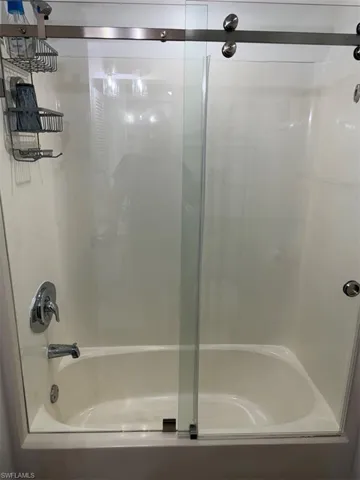 Bathroom featuring bath / shower combo with glass door