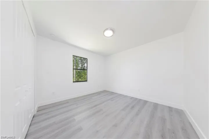 Unfurnished room with light wood-style floors and baseboards