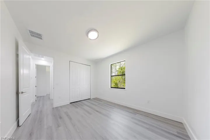 Unfurnished bedroom with light wood-style flooring and a closet