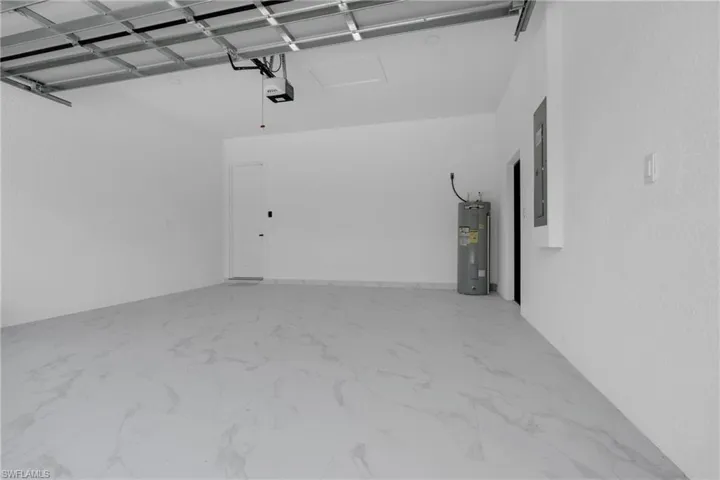 Spacious garage featuring light-toned flooring, white walls, and an automatic garage door opener