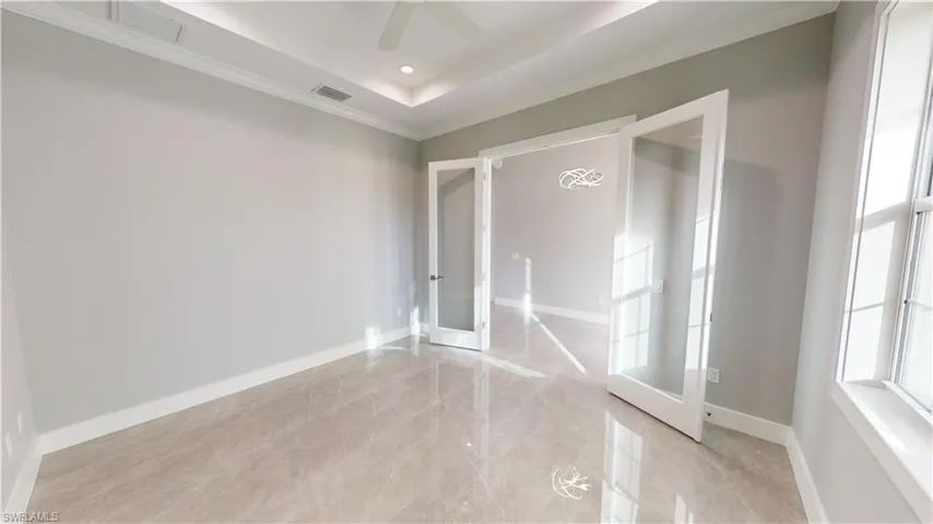 Den with tray ceiling and french doors