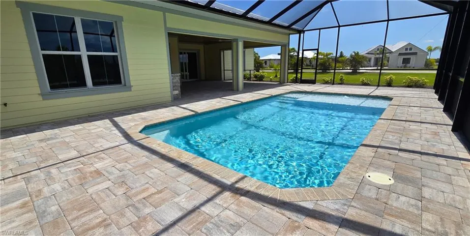 View of pool with a patio and glass enclosure