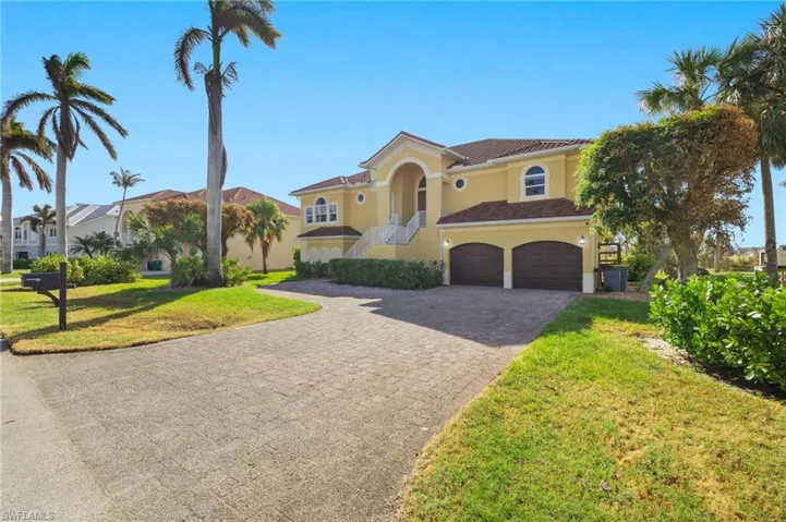 Mediterranean / spanish home featuring a front lawn and a garage
