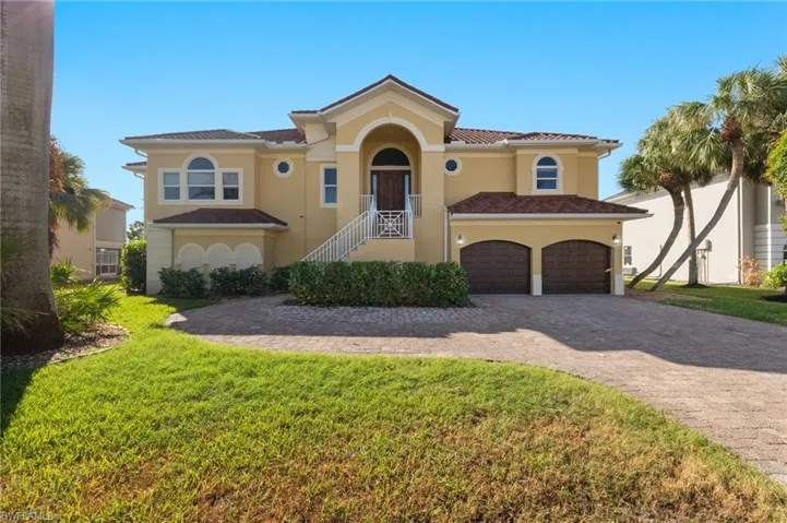 Mediterranean / spanish-style house with a front lawn and a garage
