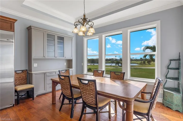 Dining room featuring ornamental molding, an inviting chandelier, and dark hardwood / wood-style flooring