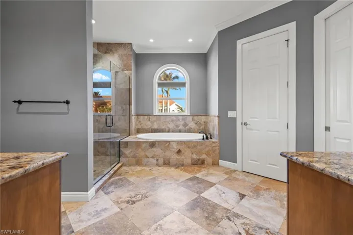 Bathroom with vanity, ornamental molding, and separate shower and tub