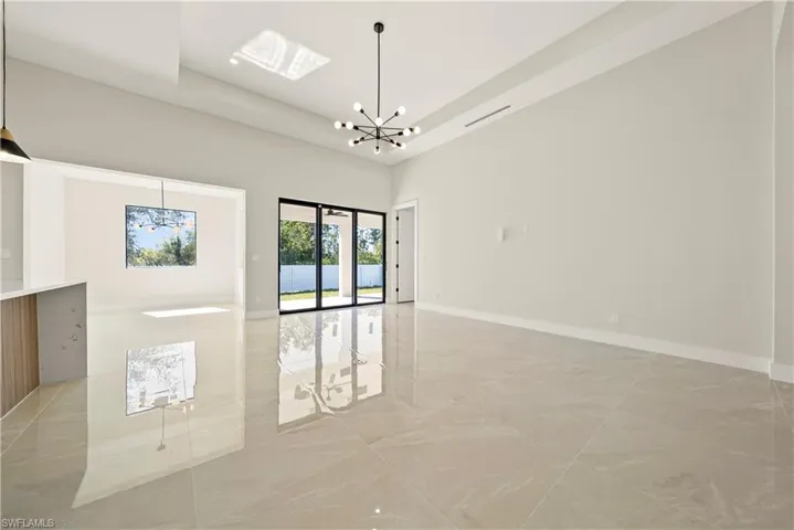 Spare room with suspended lighting and a tray ceiling
