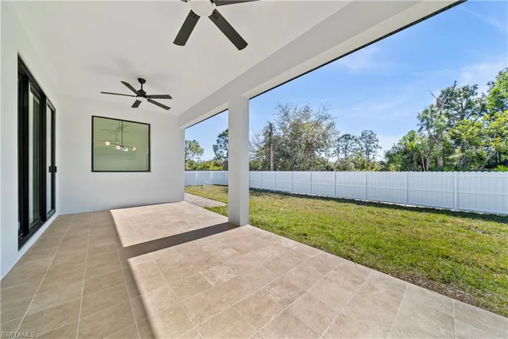 Fenced backyard with a patio area and ceiling fan