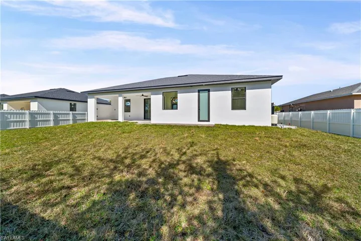 Rear view of property with a ceiling fan, a patio area, a fenced backyard, and stucco siding