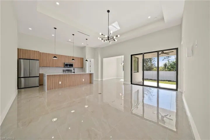 Kitchen with open floor plan, stainless steel appliances, suspended lighting, a spacious island, and modern cabinets