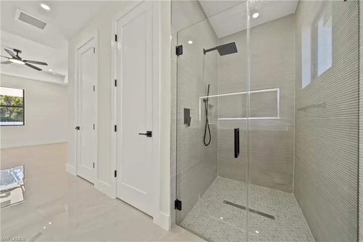 Bathroom featuring a stall shower, ceiling fan, and recessed lighting