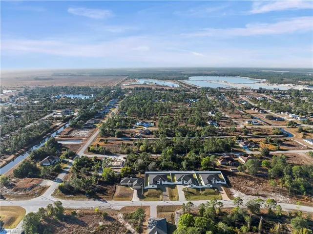 Aerial view of property and surrounding area with a large body of water and nearby suburban area