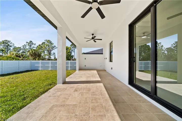 Fenced backyard featuring a patio area and ceiling fan