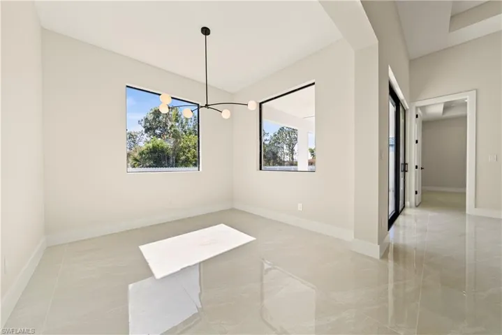 Unfurnished dining area with hanging lights and baseboards