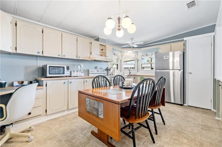 Dining room featuring hanging lights, ceiling fan, lofted ceiling, and crown molding
