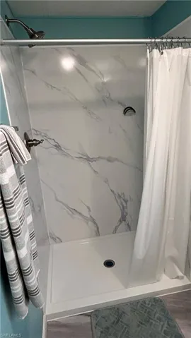 Bathroom with a marble finish shower