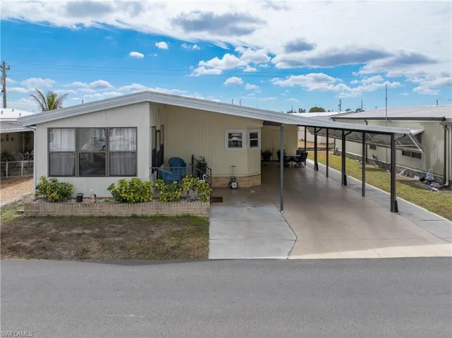 View of front of property with a carport and driveway