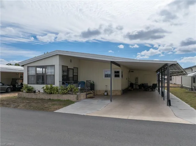 Manufactured / mobile home featuring a carport and concrete driveway