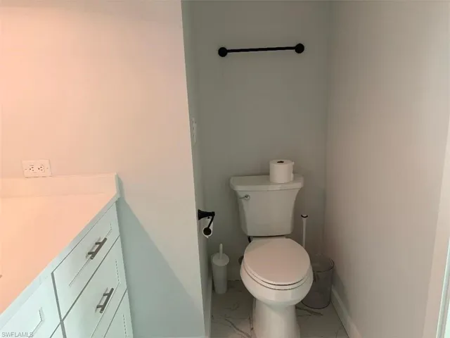 Bathroom with vanity and light marble finish flooring