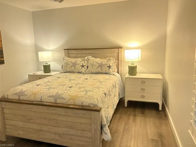 Bedroom with dark wood finished floors and baseboards
