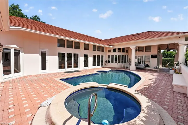 The property features an expansive outdoor area with a swimming pool and an integrated spa