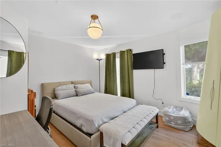 This room features white walls, hardwood flooring, and a window providing natural light