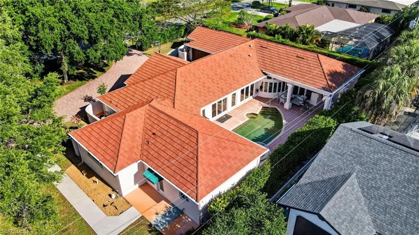 Property with a red tile roof, a swimming pool, and a paved patio area