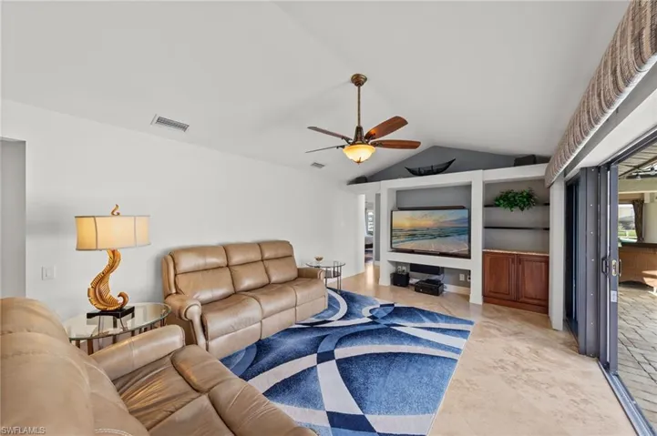Living room with a ceiling fan and light tile patterned flooring