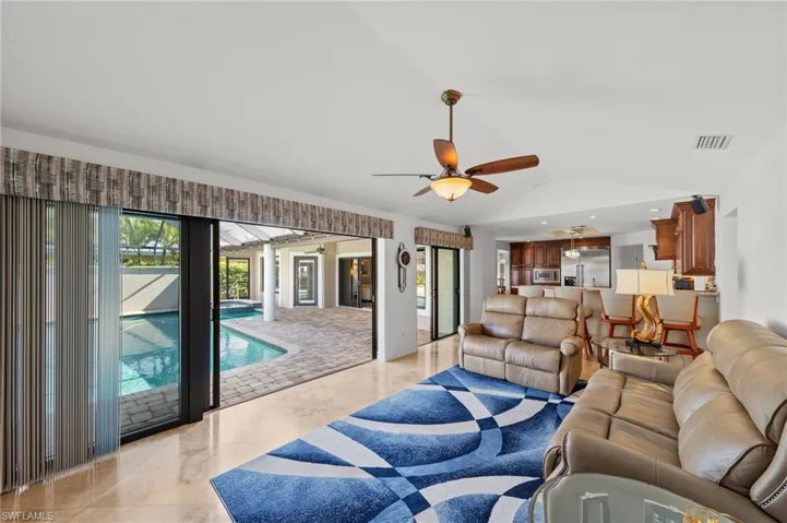 Living room featuring lofted ceiling, ceiling fan, and recessed lighting