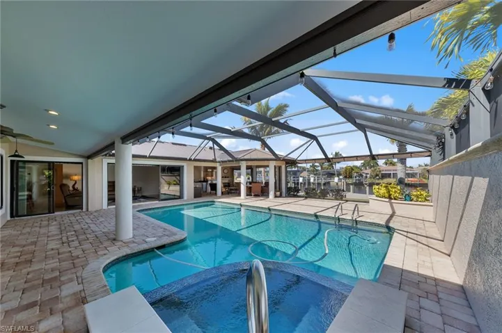 Integrated pool / spa featuring a patio area, a sunroom, and a lanai