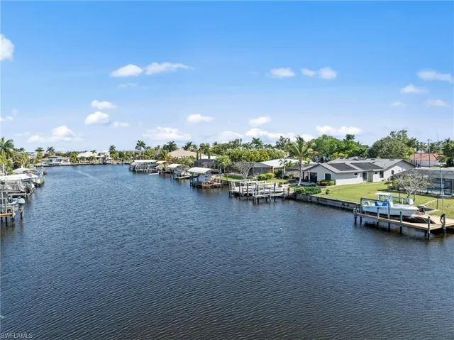 Water view with a dock and nearby suburban area