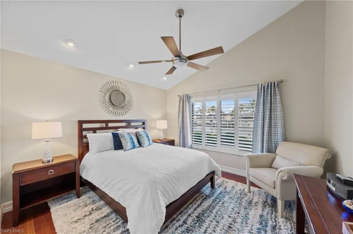 Bedroom featuring lofted ceiling, wood finished floors, a ceiling fan, and recessed lighting