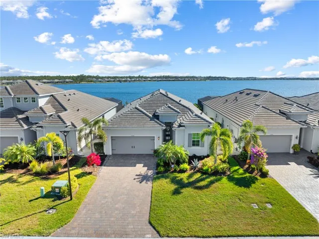 View of front facade with a garage, a water view, and a front yard