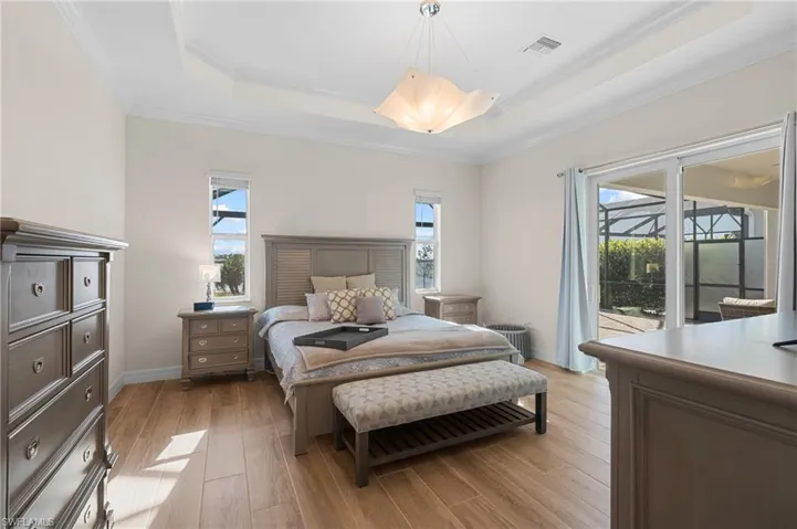 Bedroom with multiple windows, access to exterior, and light wood-type flooring