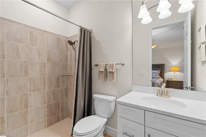 Bathroom featuring a shower with curtain, vanity, and toilet