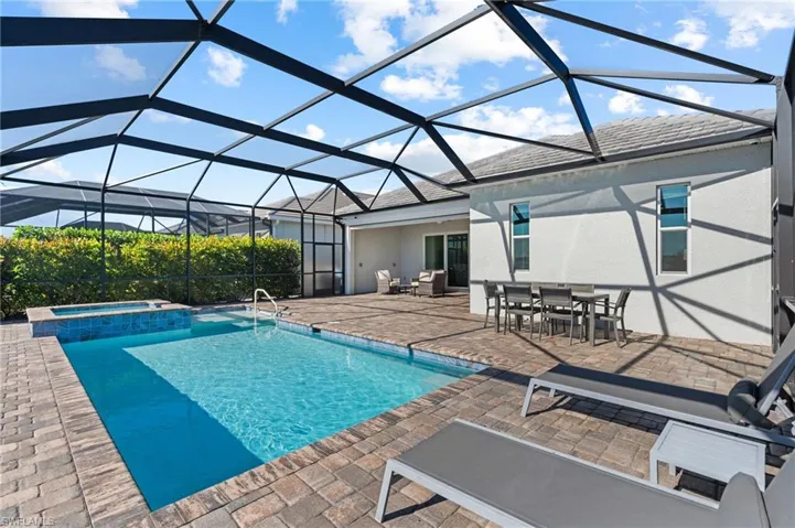 View of swimming pool with a patio area, a lanai, and an in ground hot tub