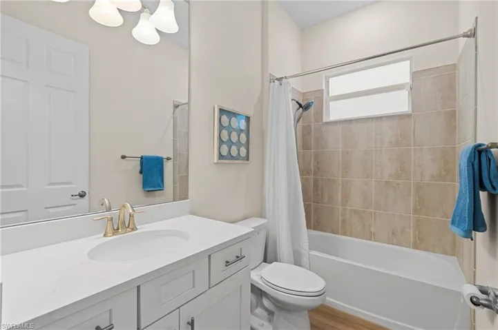 Full bathroom with hardwood / wood-style floors, vanity, toilet, and shower / bath combo