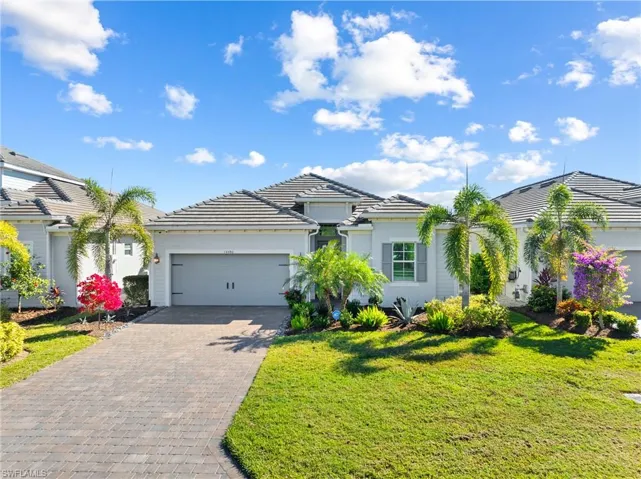 View of front of property featuring a garage and a front yard