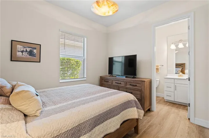 Bedroom featuring ensuite bathroom, sink, and light wood-type flooring