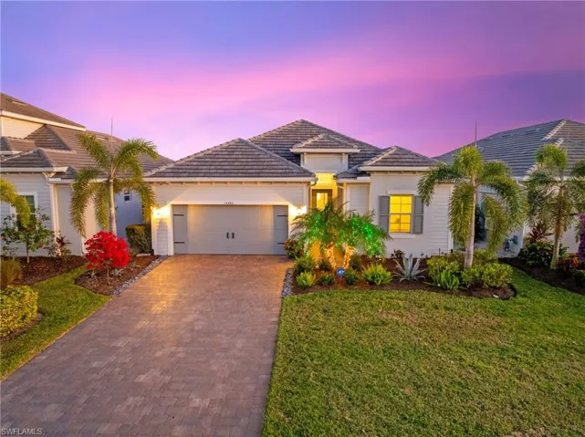 Mediterranean / spanish-style house with a lawn and a garage