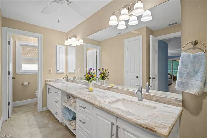 Full bathroom featuring a sink, visible vents, toilet, and double vanity