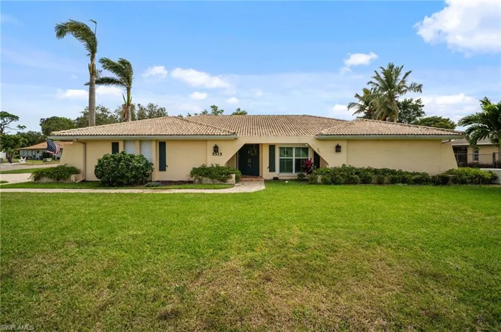 Ranch-style home featuring stucco siding, a tile roof, and a front yard