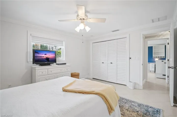 Bedroom featuring light tile patterned floors, visible vents, a closet, and ornamental molding
