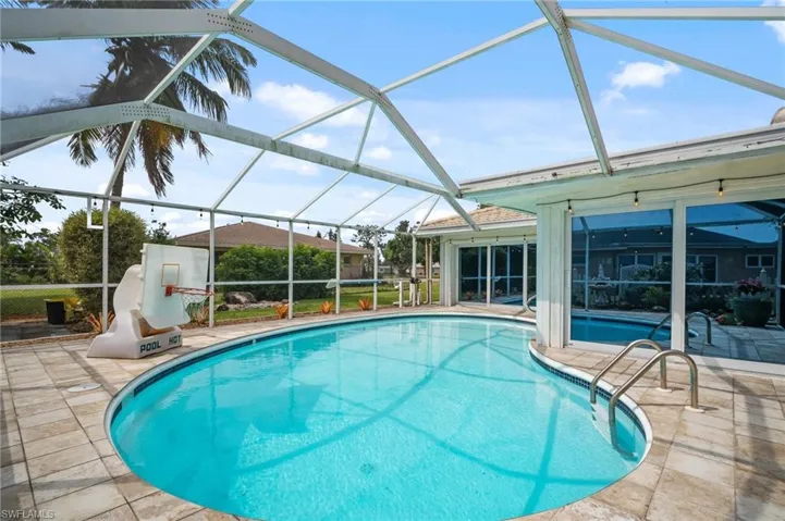Pool featuring glass enclosure and a patio area