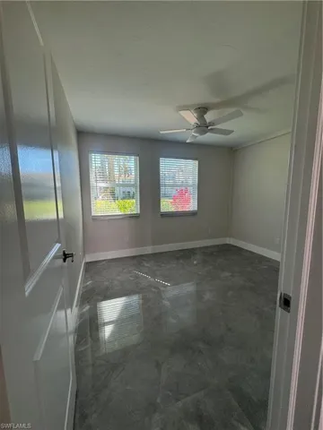 Unfurnished room with baseboards and ceiling fan