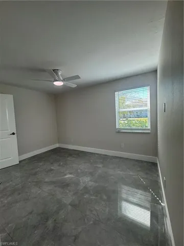 Spare room with baseboards and ceiling fan