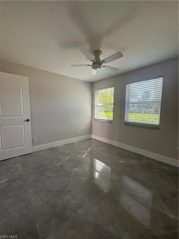 Empty room featuring a ceiling fan and concrete flooring