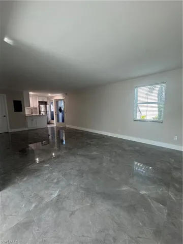 Unfurnished living room with baseboards