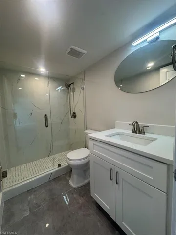 Full bathroom featuring vanity and a marble finish shower
